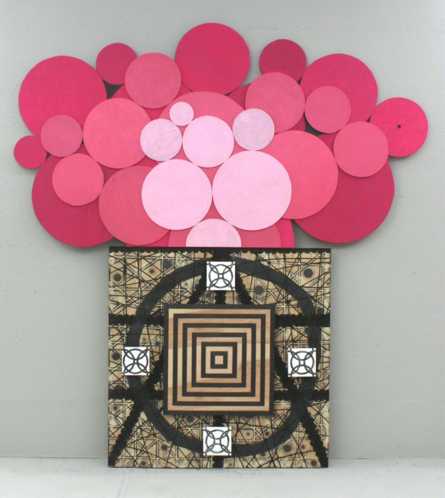 Abstract artwork featuring layered pink circular forms above a geometric black-and-white patterned panel with concentric square details.